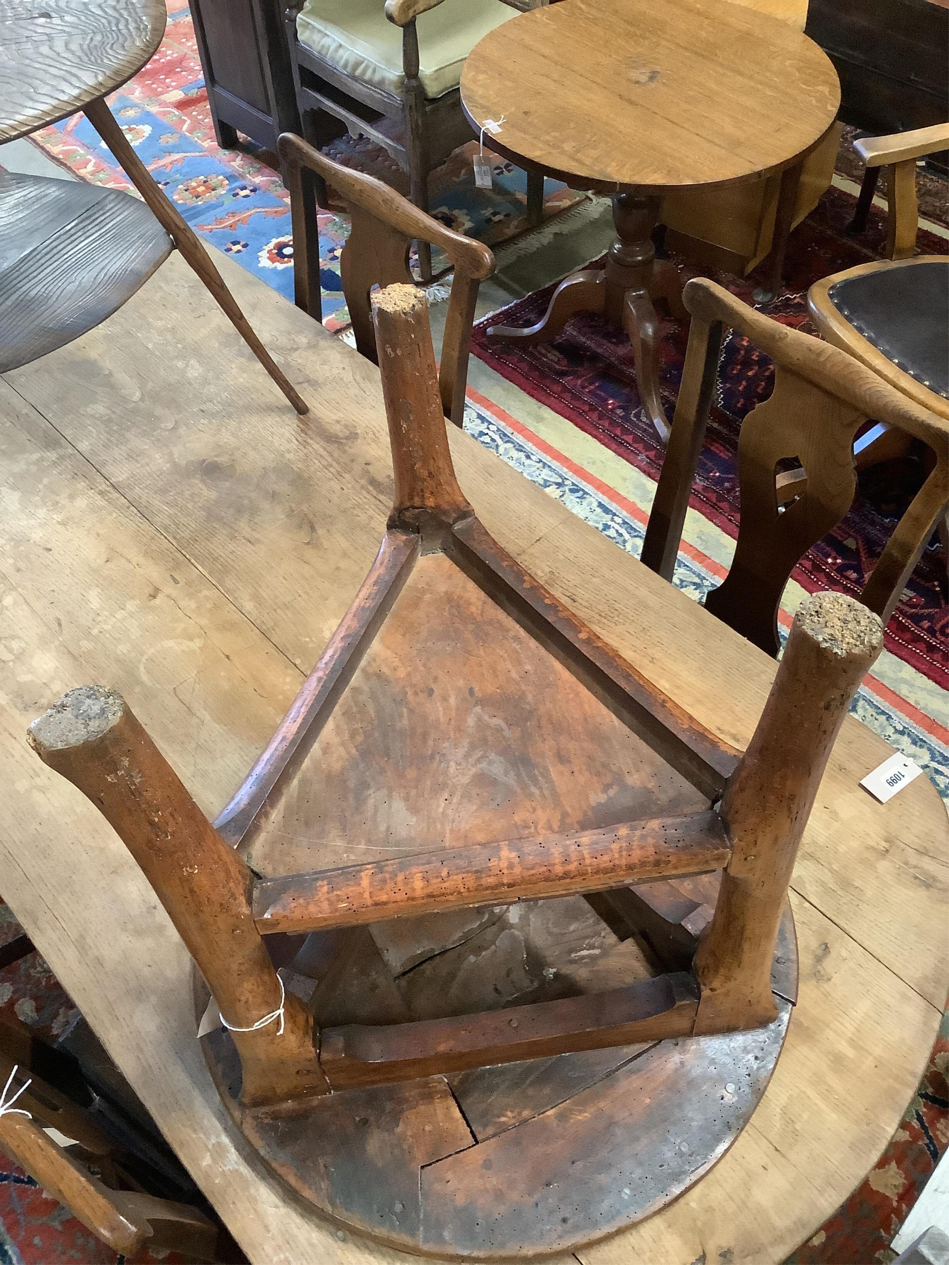 An 18th century elm cricket table, width 63cm, height 64cm. Condition - extensive splitting and old patches and repairs to the top, legs probably reduced, but full of character